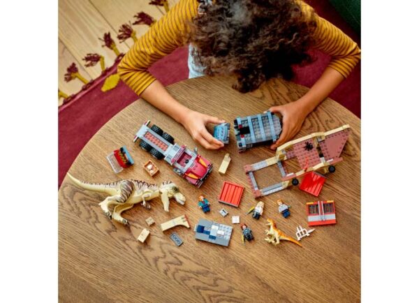 copil jucandu-se cu LEGO Jurassic World Evadarea dinozaurilor T.rex si Atrociraptor